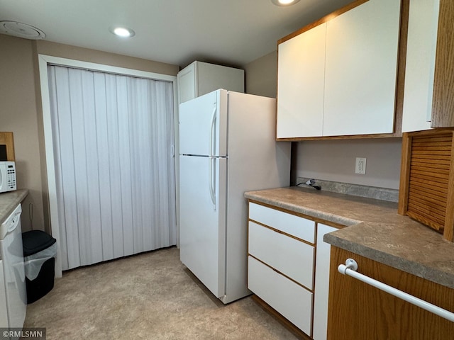 kitchen with recessed lighting, white appliances, and white cabinets