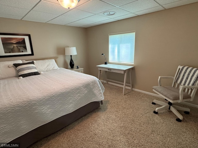 carpeted bedroom featuring a paneled ceiling and baseboards