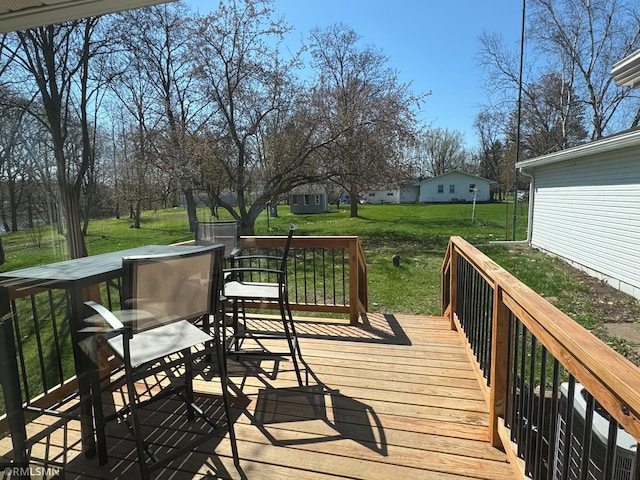 wooden terrace featuring a yard and outdoor dining area