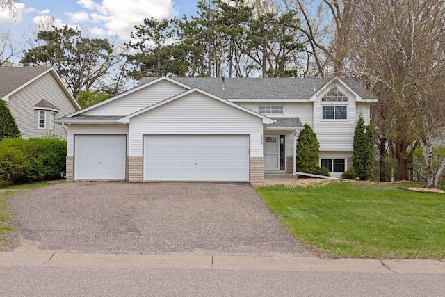 view of front of house featuring driveway, roof with shingles, a garage, brick siding, and a front lawn