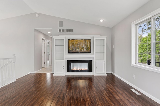 unfurnished living room with visible vents, wood finished floors, vaulted ceiling, and a healthy amount of sunlight