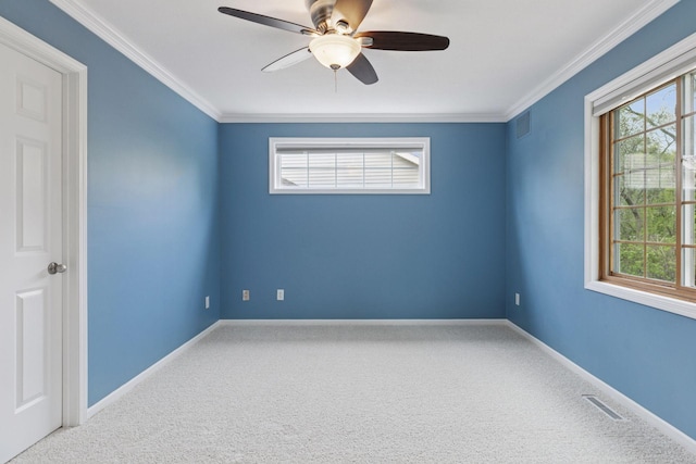carpeted empty room with crown molding, a ceiling fan, baseboards, and visible vents