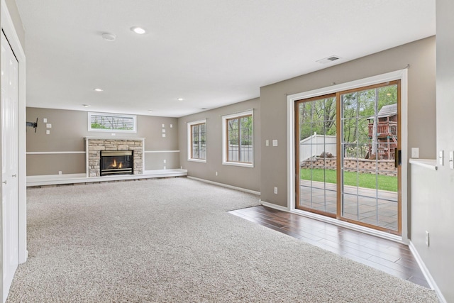 unfurnished living room featuring carpet flooring, a fireplace, recessed lighting, baseboards, and visible vents