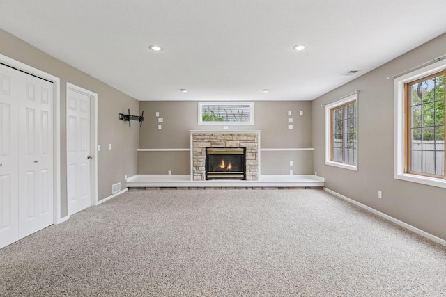 unfurnished living room featuring visible vents, a fireplace, baseboards, carpet, and recessed lighting