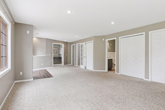 unfurnished living room with baseboards, carpet, french doors, and recessed lighting