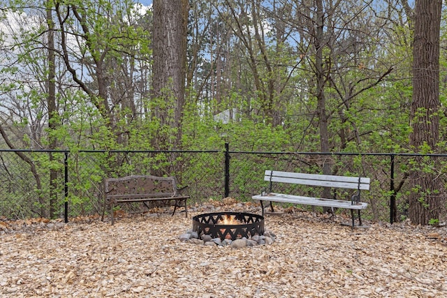 view of community with an outdoor fire pit and fence
