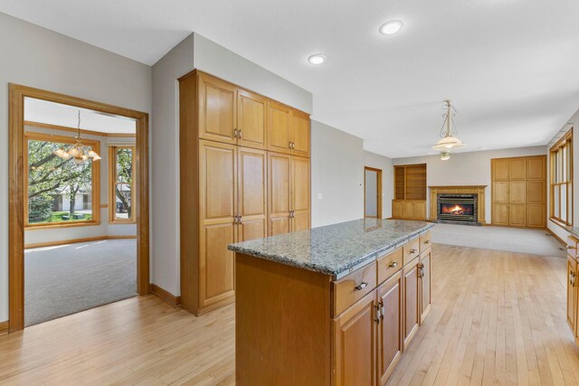 3088 Canyon Rd, Chaska, MN 55318 - kitchen with an inviting chandelier, light wood-style flooring, baseboards, and light stone countertops