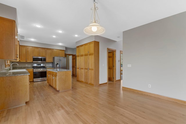 3088 Canyon Rd, Chaska, MN 55318 - kitchen with appliances with stainless steel finishes, a sink, light wood-style floors, a kitchen island, and visible vents