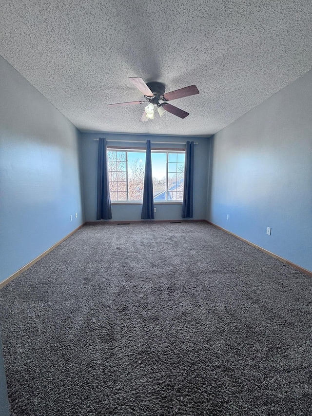 carpeted spare room with baseboards, a textured ceiling, and ceiling fan