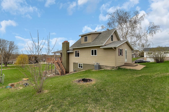 224 Spring St, Holdingford, MN 56340 - rear view of house featuring stairway, a lawn, central AC unit, an outdoor fire pit, and a shingled roof