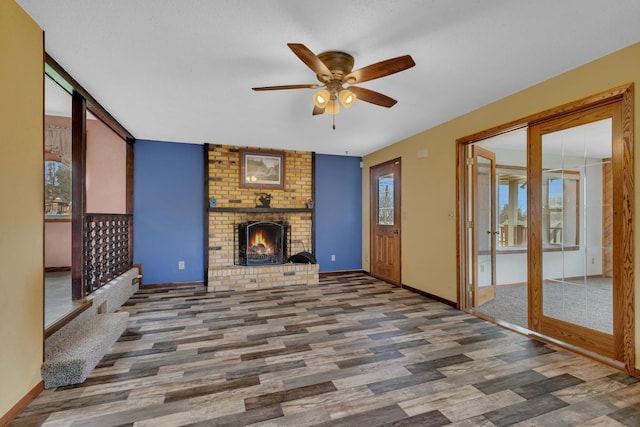224 Spring St, Holdingford, MN 56340 - unfurnished living room with baseboards, a fireplace, ceiling fan, and wood finished floors