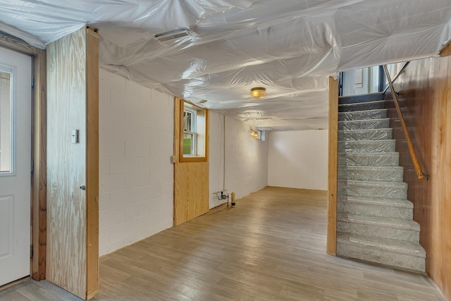 224 Spring St, Holdingford, MN 56340 - below grade area featuring stairs, concrete block wall, visible vents, and wood finished floors
