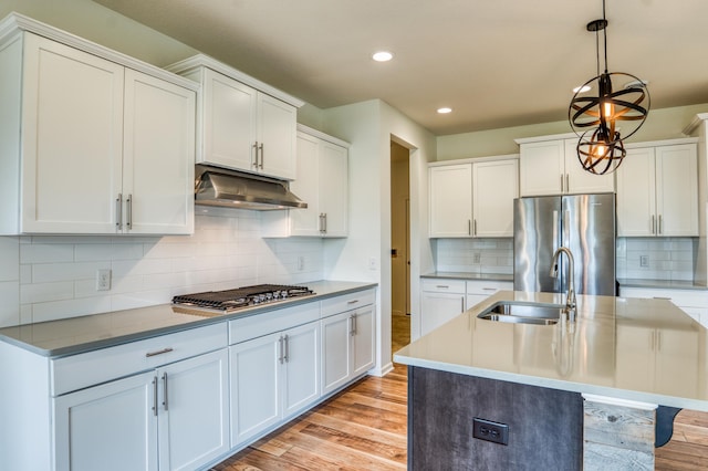 15637 Eddy Creek Way, Apple Valley, MN 55124 - kitchen featuring under cabinet range hood, appliances with stainless steel finishes, a sink, light wood-type flooring, and recessed lighting