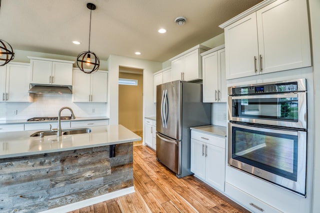 15637 Eddy Creek Way, Apple Valley, MN 55124 - kitchen with appliances with stainless steel finishes, light wood-style floors, backsplash, decorative light fixtures, and recessed lighting