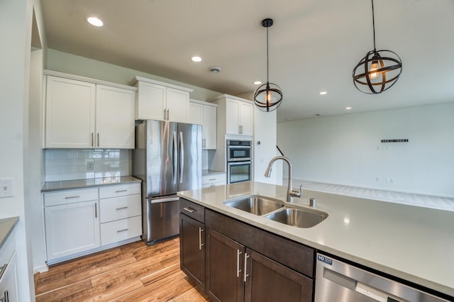15637 Eddy Creek Way, Apple Valley, MN 55124 - kitchen with a sink, stainless steel appliances, light wood finished floors, white cabinets, and pendant lighting