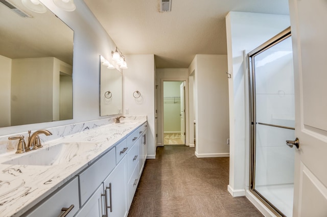 15637 Eddy Creek Way, Apple Valley, MN 55124 - bathroom with double vanity, baseboards, and a shower with shower door