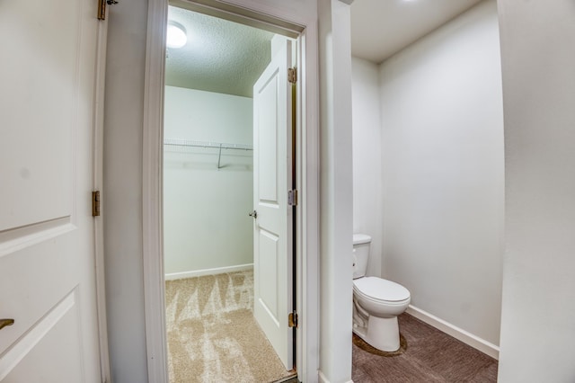 15637 Eddy Creek Way, Apple Valley, MN 55124 - bathroom featuring toilet, a textured ceiling, and baseboards