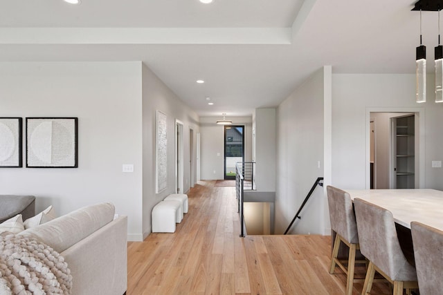 hall with recessed lighting, baseboards, an upstairs landing, and light wood-style floors