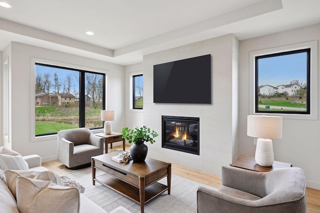 living room with baseboards, a fireplace, recessed lighting, and light wood-style flooring
