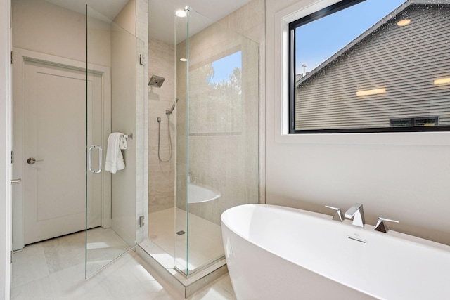 bathroom featuring a freestanding bath, tile patterned floors, and a stall shower