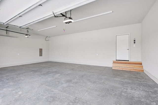 garage with baseboards, a garage door opener, and electric panel