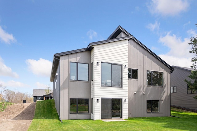 rear view of property featuring board and batten siding and a yard