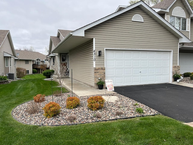 view of front of property with driveway, cooling unit, a garage, a front yard, and roof with shingles