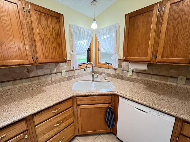 kitchen featuring backsplash, brown cabinetry, a sink, and white dishwasher