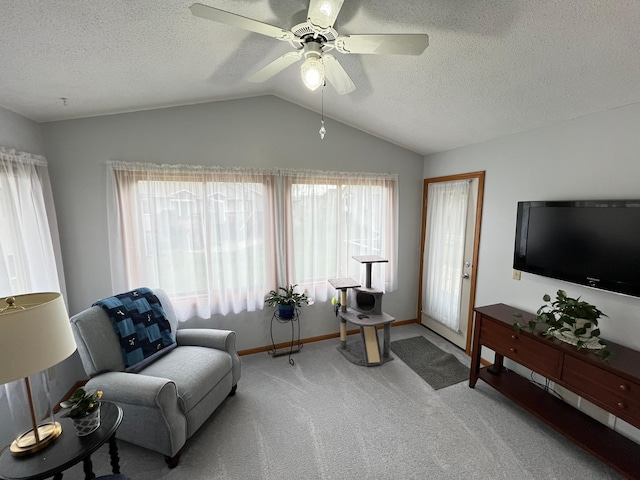 living room featuring a textured ceiling, vaulted ceiling, carpet flooring, a ceiling fan, and baseboards