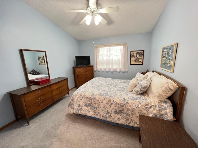 bedroom with a ceiling fan, a textured ceiling, light carpet, and lofted ceiling
