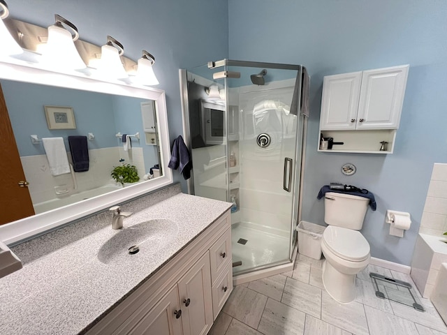 full bathroom with a shower stall, vanity, toilet, and a washtub