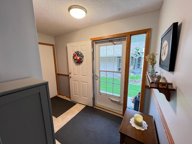 entryway with a textured ceiling and light tile patterned floors