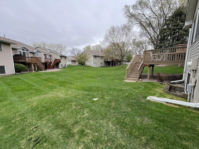 view of yard featuring stairway, a residential view, and a wooden deck