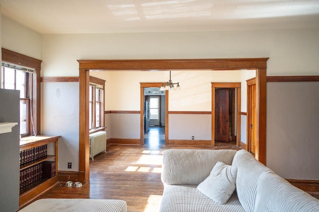 560 7th St, Red Wing, MN 55066 - living area with a notable chandelier, plenty of natural light, wood finished floors, and radiator heating unit