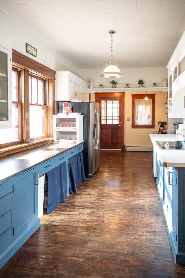 560 7th St, Red Wing, MN 55066 - kitchen featuring a baseboard radiator, blue cabinets, dark wood finished floors, a sink, and glass insert cabinets