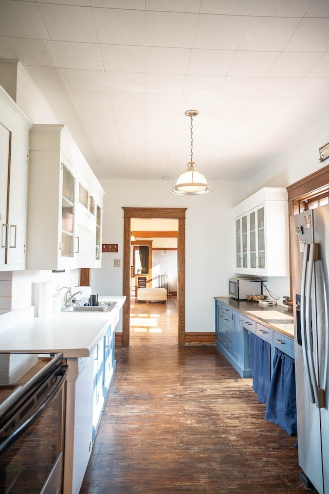 560 7th St, Red Wing, MN 55066 - kitchen featuring glass insert cabinets, hanging light fixtures, white cabinetry, dark wood-type flooring, and stainless steel appliances