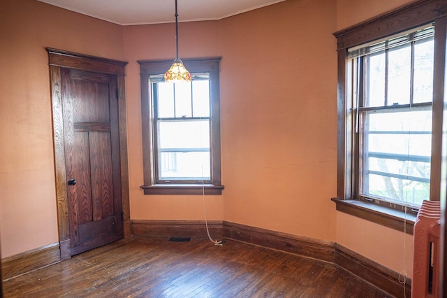560 7th St, Red Wing, MN 55066 - spare room featuring wood-type flooring, baseboards, a healthy amount of sunlight, and visible vents