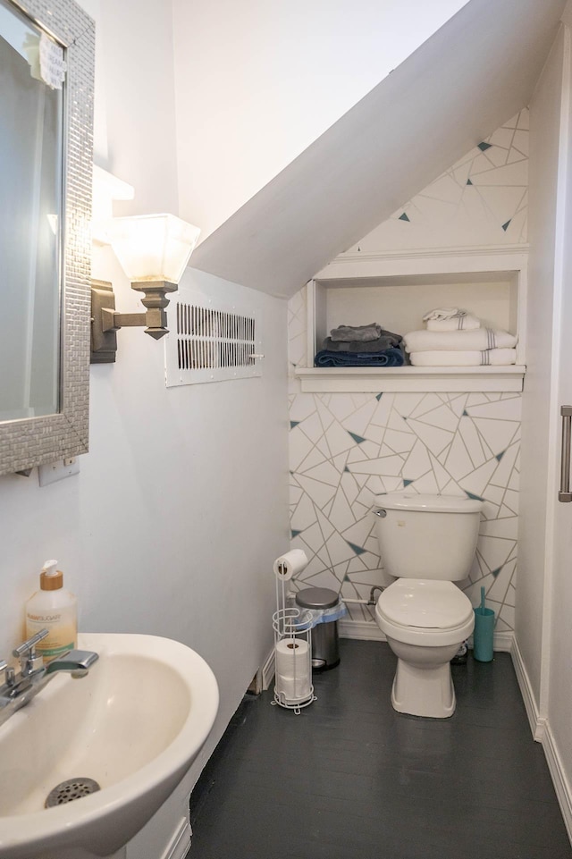 560 7th St, Red Wing, MN 55066 - bathroom with toilet, visible vents, a sink, and wood finished floors