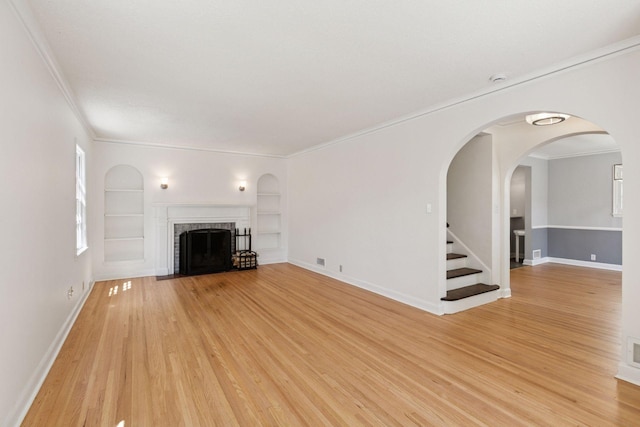 5620 Stevens Ave, Minneapolis, MN 55419 - unfurnished living room featuring built in features, crown molding, light wood-type flooring, a fireplace with flush hearth, and stairs
