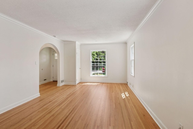 5620 Stevens Ave, Minneapolis, MN 55419 - empty room featuring crown molding, light wood-type flooring, arched walkways, and a textured ceiling