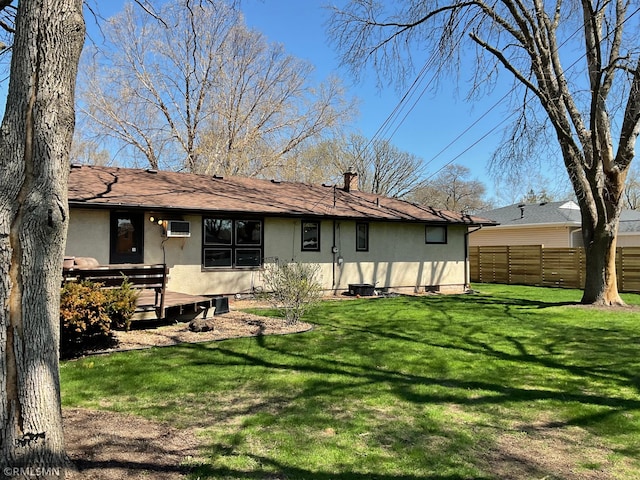 back of property with stucco siding, a deck, and a chimney