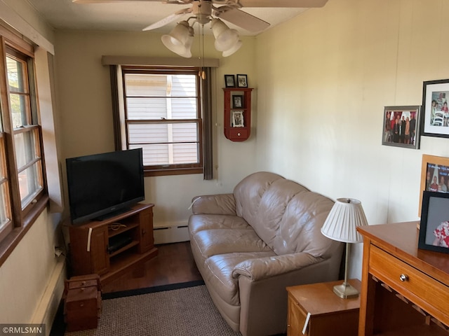 carpeted living area with a baseboard heating unit, a ceiling fan, and plenty of natural light
