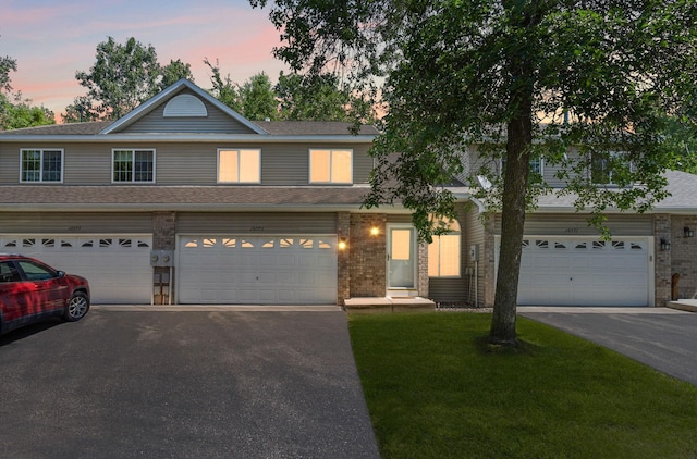 10773 Tamarack Cir NW, Coon Rapids, MN 55433 - view of front facade with driveway, brick siding, a front lawn, and a garage