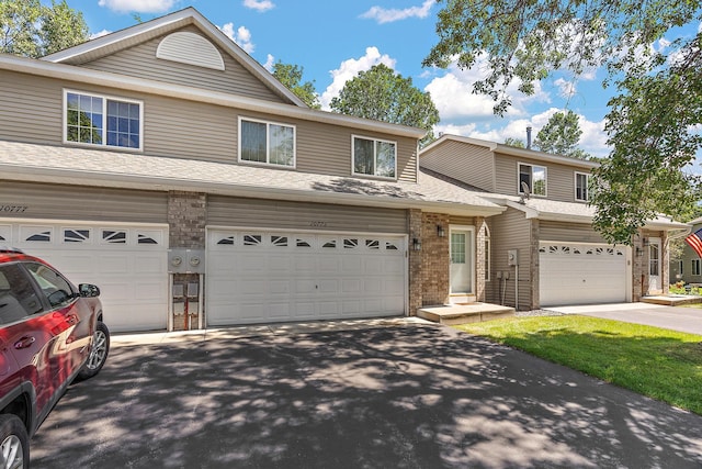 10773 Tamarack Cir NW, Coon Rapids, MN 55433 - view of front of house with driveway, brick siding, a garage, and roof with shingles