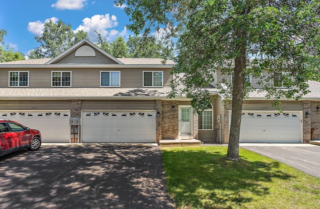 10773 Tamarack Cir NW, Coon Rapids, MN 55433 - view of front of property featuring driveway, an attached garage, and brick siding