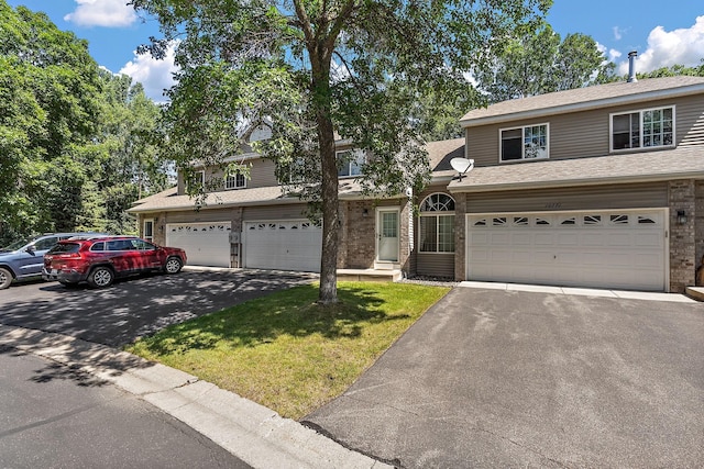 10773 Tamarack Cir NW, Coon Rapids, MN 55433 - traditional home featuring driveway, brick siding, a front yard, and an attached garage