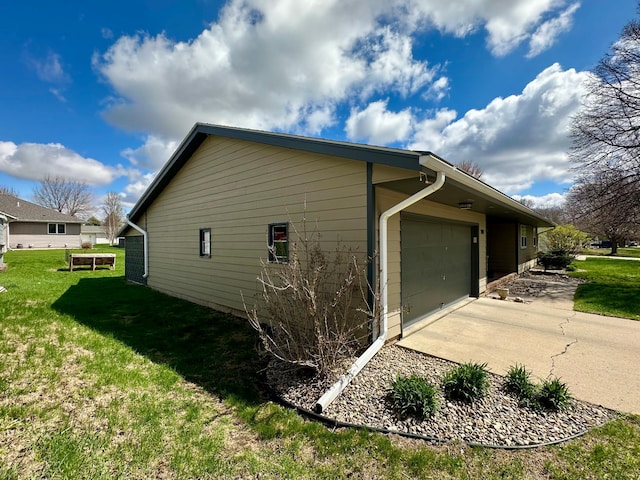 view of side of property featuring an attached garage, a lawn, and concrete driveway