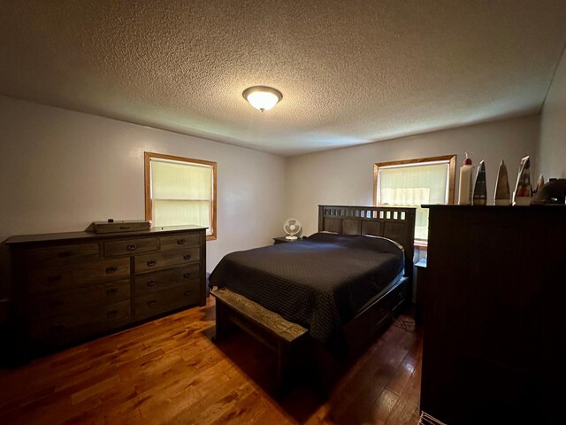 bedroom featuring a textured ceiling and wood finished floors