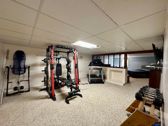 exercise room with carpet floors and a paneled ceiling
