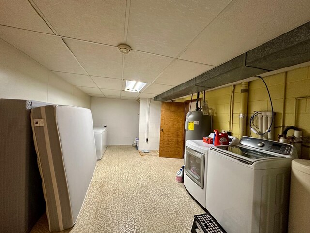 laundry area with laundry area, water heater, and washing machine and dryer